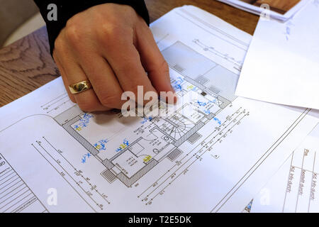 Architect, engineer discussing blueprint of a house with its clients in the office Stock Photo