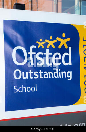 Vinyl banner / outside / outdoors sign to advertise the fact that this school has been judged to be outstanding by OFSTED. UK. (106) Stock Photo