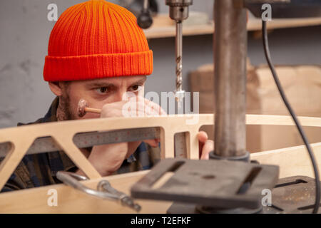 Construction Worker Using Drill To wood. Drill machine on the table in renovation work at home. Home repair concepts, close up. Stock Photo