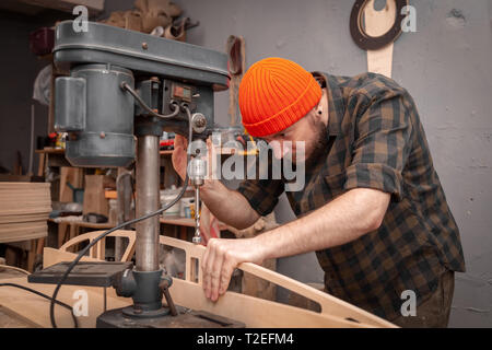 Construction Worker Using Drill To wood. Drill machine on the table in renovation work at home. Home repair concepts, close up. Stock Photo