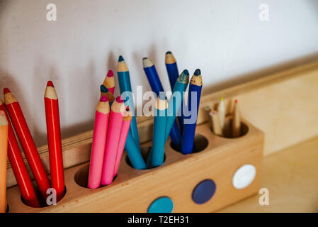 colored pencils in a container on a wooden table, close up on blue Stock Photo