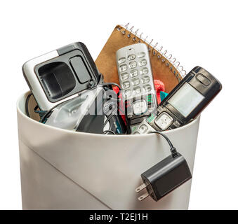 Horizontal shot of land line telephones thrown away in a trashcan.  This shot is from the side.  Only the top half of the trashcan shows. Stock Photo