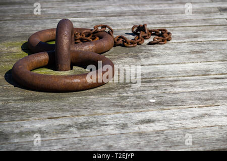 Close-up of rusty boat mooring rings on timber quayside Stock Photo