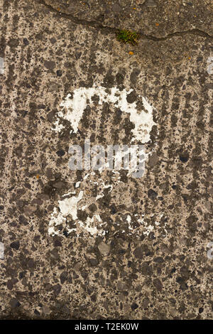 Detail of Crumbling White Painted Number Two On Rough Concrete Ground Stock Photo