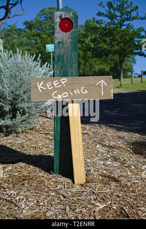 Handwritten Keep Going with arrow wooden sign Stock Photo