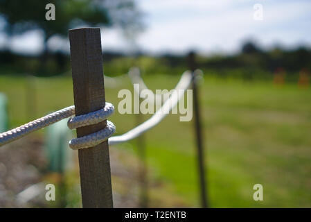 Close up view of white rope wrapped around wooden post Stock Photo