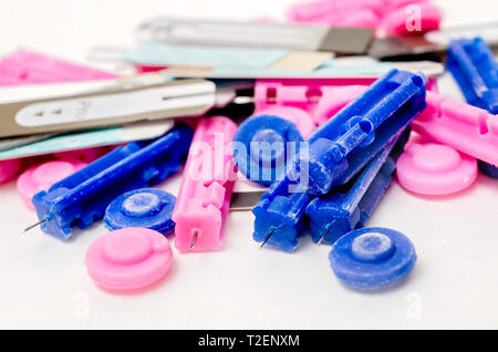 A pile of disposable blood lancets is pictured on white with ketone and blood glucose testing strips, March 30, 2019, in Coden, Alabama. Stock Photo