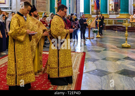 Saint Petersburg, Russia - September 10, 2017: Russian Orthodox priest in traditional clothing at mass and parishioners in Saint Isaac's Cathedral Stock Photo