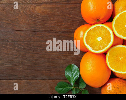 Oranges and orange halves placed on a wooden table Stock Photo