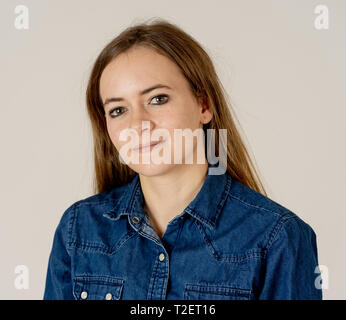 Studio portrait of young beautiful teenager woman with blond hair wearing jean shirt feeling confident, relaxed posing and modeling. Isolated on neutr Stock Photo