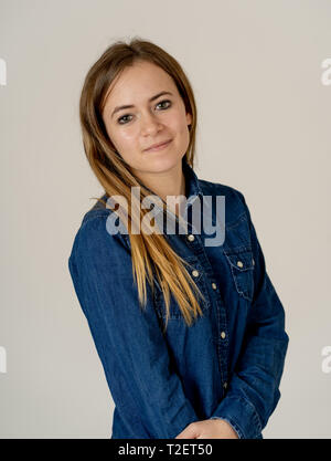 Studio portrait of young beautiful teenager woman with blond hair wearing jean shirt feeling confident, relaxed posing and modeling. Isolated on neutr Stock Photo