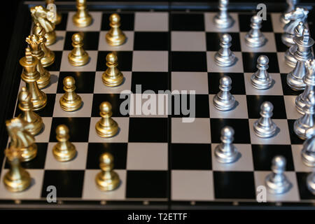 From above set of golden and silver chess pieces placed on board before match Stock Photo