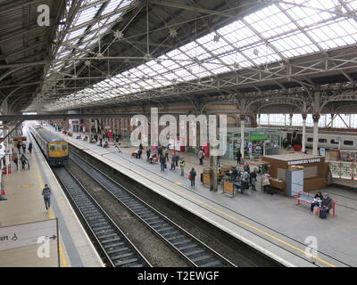 View looking down on the platforms and train tracks of Preston railway station showing Victorian architecture, glazed roof, platforms and trains. Stock Photo