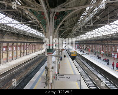 View looking down on to the platforms at Preston railway station showing Victorian architecture, rail tracks, glazed roof, platforms and trains. Stock Photo