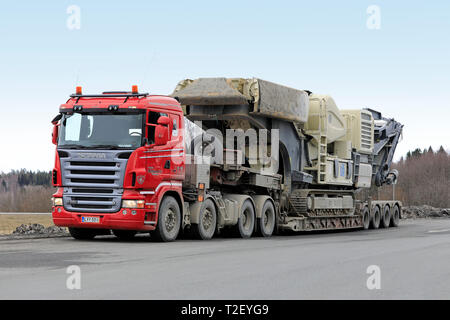 Forssa, Finland - March 30, 2019: Red Scania R620 semi trailer of Veljekset Makitalo Oy with a load of Metso Lokotrack crusher parked on a truck stop. Stock Photo