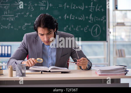 Young handsome math teacher in classroom Stock Photo