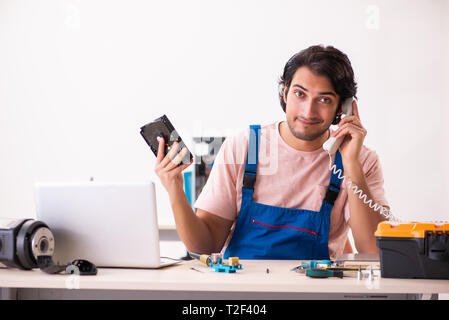 Young male contractor repairing computer Stock Photo