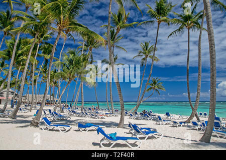 Tanning chairs with towels on a tropical resort's beach. Stock Photo