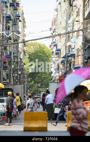 Daily traffic and city life on the narrow streets of Yangon during sunset. Stock Photo
