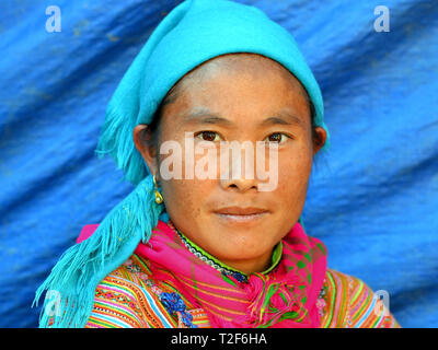 Young Vietnamese Flower H'mong woman wears a colorful embroidered traditional Flower H'mong costume and poses for the camera. Stock Photo