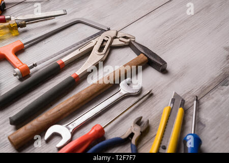 Screwdriver,hammer,tape measure and other tool for construction tools on gray wooden background,industry engineer tool concept.still-life. Stock Photo