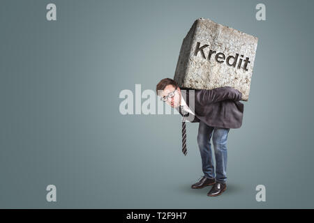 Concept of a businessman bending under the burden of a heavy loan. Translation on stone: “Loan” Stock Photo