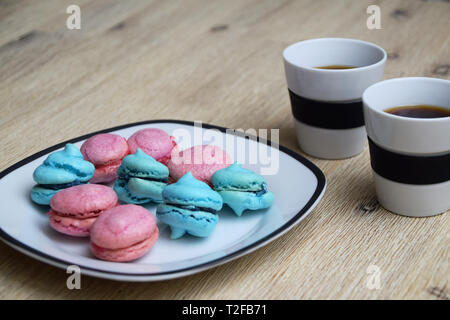 Coffee break with espresso and blue and pink macarons with blueberry and raspberry filling Stock Photo