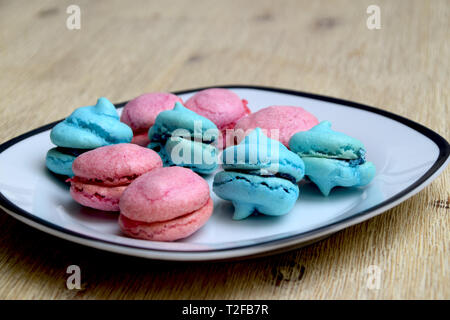 A plate with blue and pink french macarons with blueberry and raspberry filling Stock Photo