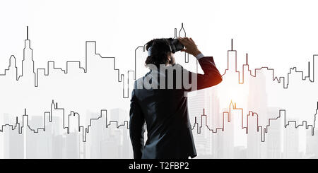 Double exposure of businessman in virtual helmet against cityscape background Stock Photo