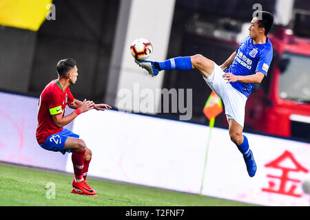 Zhengzhou, China. 31st Mar, 2019. Brazilian football player Olivio da Rosa, also known as Ivo, left, of Henan Jianye challenges a player of Shanghai Greenland Shenhua in their 3rd round match during the 2019 Chinese Football Association Super League (CSL) in Zhengzhou city, central China's Henan province, 31 March 2019. Shanghai Greenland Shenhua defeated Henan Jianye 2-1. Credit: Matt Buxton/Alamy Live News