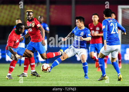 Zhengzhou, China. 31st Mar, 2019. Cameroonian football player Christian Bassogog, left, of Henan Jianye challenges a player of Shanghai Greenland Shenhua in their 3rd round match during the 2019 Chinese Football Association Super League (CSL) in Zhengzhou city, central China's Henan province, 31 March 2019. Shanghai Greenland Shenhua defeated Henan Jianye 2-1. Credit: Matt Buxton/Alamy Live News