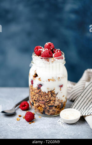 Granola with greek yogurt and red berries in jar. Copy space for text. Concept of dieting, healthy eating, healthy lifestyle Stock Photo
