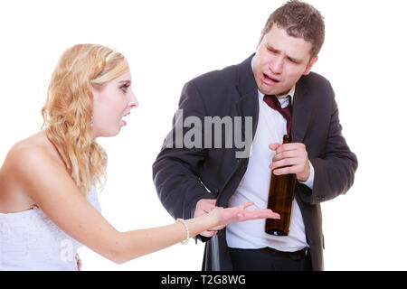 Addiction in relationship, marriage problems and troubles concept. Bride having argument with drunk alcoholic groom. Stock Photo