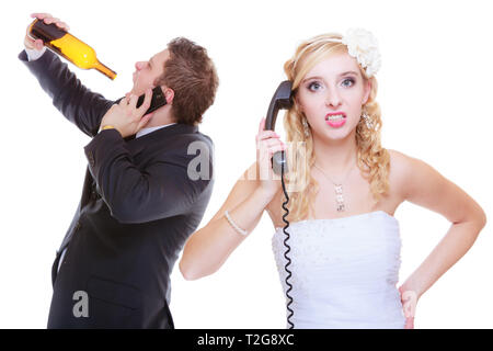 Addiction in relationship, marriage problems and troubles concept. Bride having argument with drunk alcoholic groom, she is calling for help Stock Photo