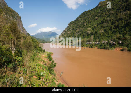 View looking north of the Nam Ou River at the village of Nong Khiaw in afternoon sunshine, Muang Ngoi District, Luang Prabang Province, Northern Laos, Stock Photo