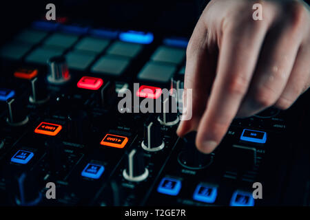 Dj hands adjusting controls on a mixer Stock Photo