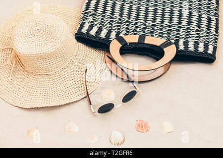 Straw hat, bag and sun glasses on a tropical beach Stock Photo
