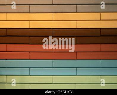 abstract pattern wall made of different colors bricks - orange, red, brown, gray, yellow, blue, green. pastel tones Stock Photo