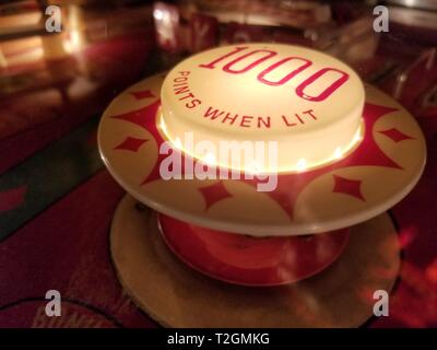 Close up shot of a '1000 Points When Lit' vintage pinball machine bumper cap, February 22, 2019. () Stock Photo