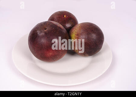 Three caimito fruits on a plate Stock Photo