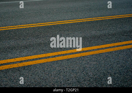 Yellow dividing lines on highway Stock Photo