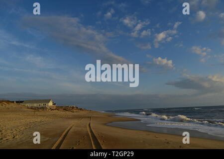 Jeep tracks through the sand by the ocean Stock Photo