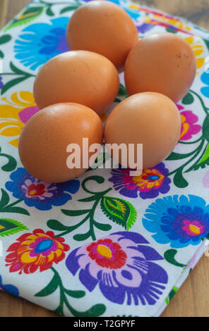 Eggs from organic farming from the village arranged on a colorful tablecloth in folk patterns Stock Photo