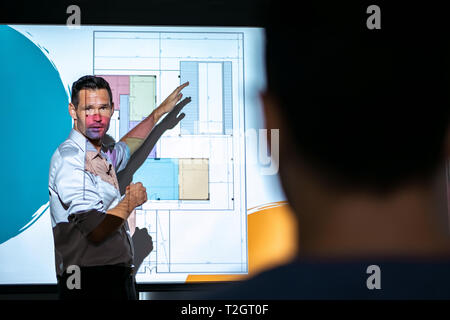 Happy architect during corporate meeting with workers. PR manager talking during presentation for housing project. Business man giving speech to peopl Stock Photo