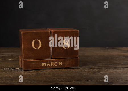 International Women’s Day vintage wooden Perpetual calendar for March 8 on a dark background Stock Photo