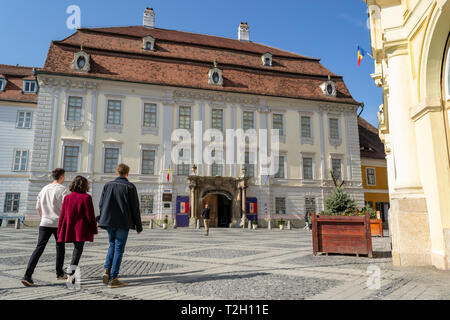 Sibiu, Romania - March 25, 2019: Young students heading towards Brukenthal National Museum in Sibiu's main pedestrian square, on a sunny Summer day. M Stock Photo