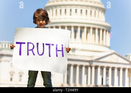 Child boy protest in front of the USA capitol in Washington holding sign saying  truth Stock Photo