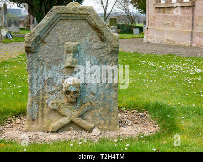 Old worn skull and crossbones on gravestone in village churchyard,, East Saltoun, East Lothian, Scotland, UK Stock Photo