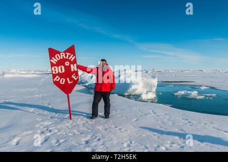 Man standing by sign at North Pole, Arctic Stock Photo