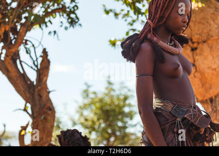 Portrait of Himba woman in traditional dress with necklace, belt and hairstyle Stock Photo